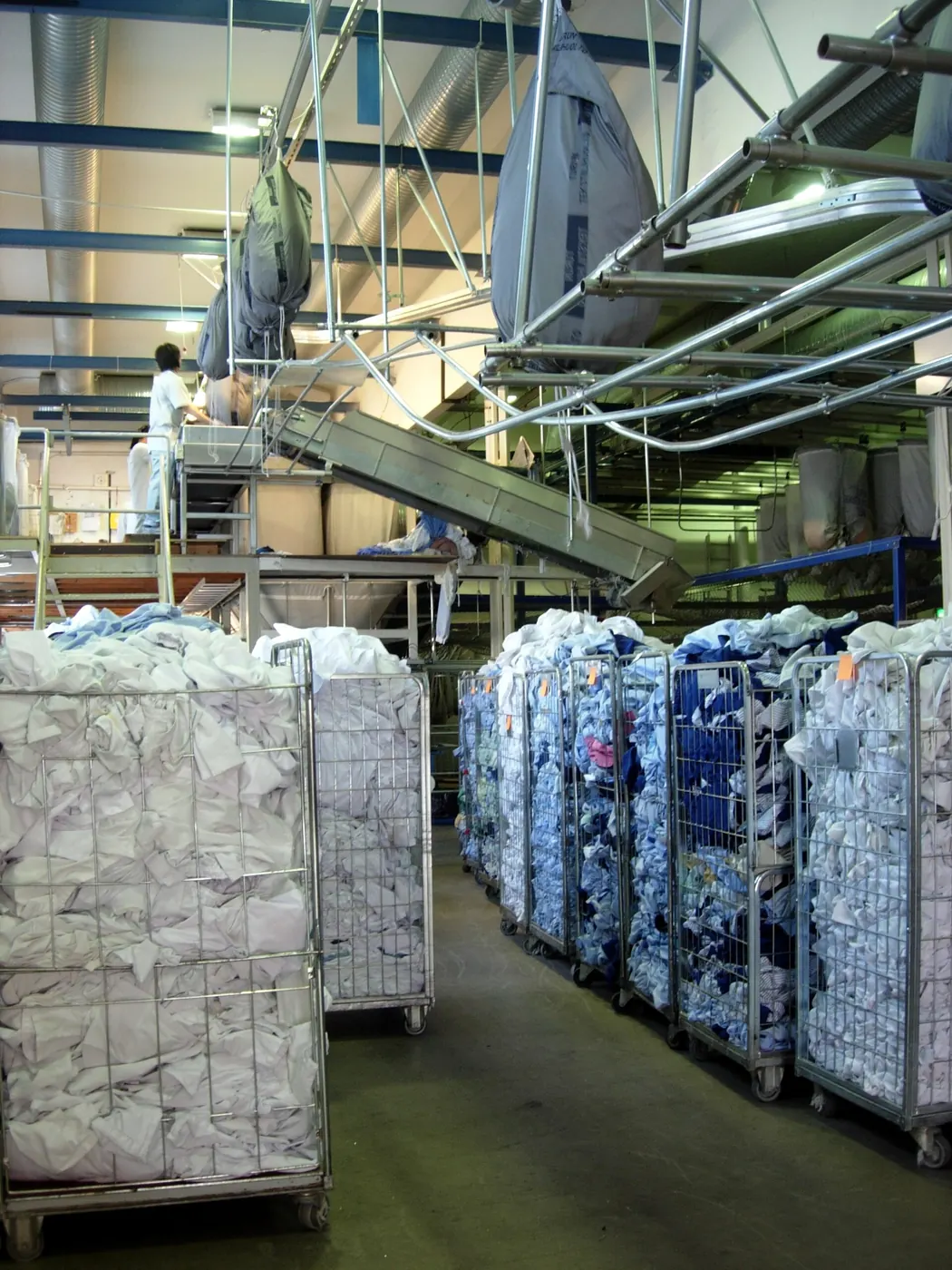 Staff sorting bulk linen in an industrial laundry
